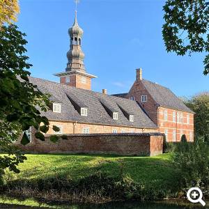Das barocke Husumer Schloss zwischen Bäumen.