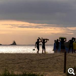 Eine Personengrouppe sind am Strand nach einem Tag surfen